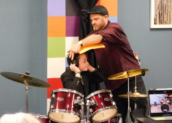 A Child's Song Drum Instructor John Olsson helps student at recital